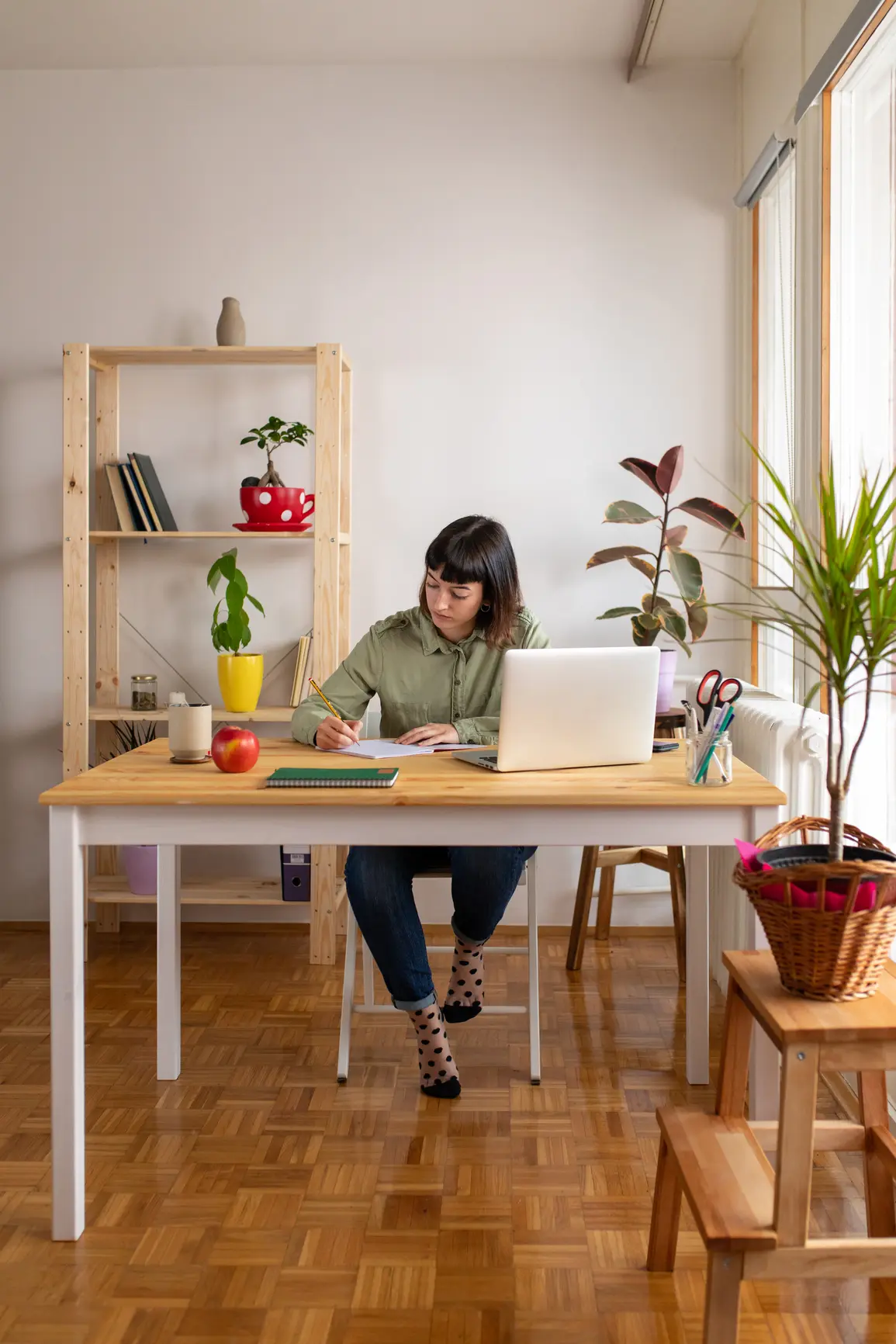 Portrait of a young student learning at home, she is sitting at the desk and doing a homework.