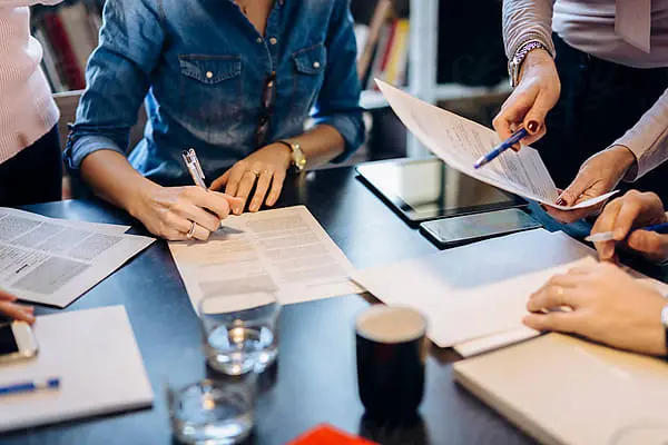 group of people sitting around a table accepting contracts