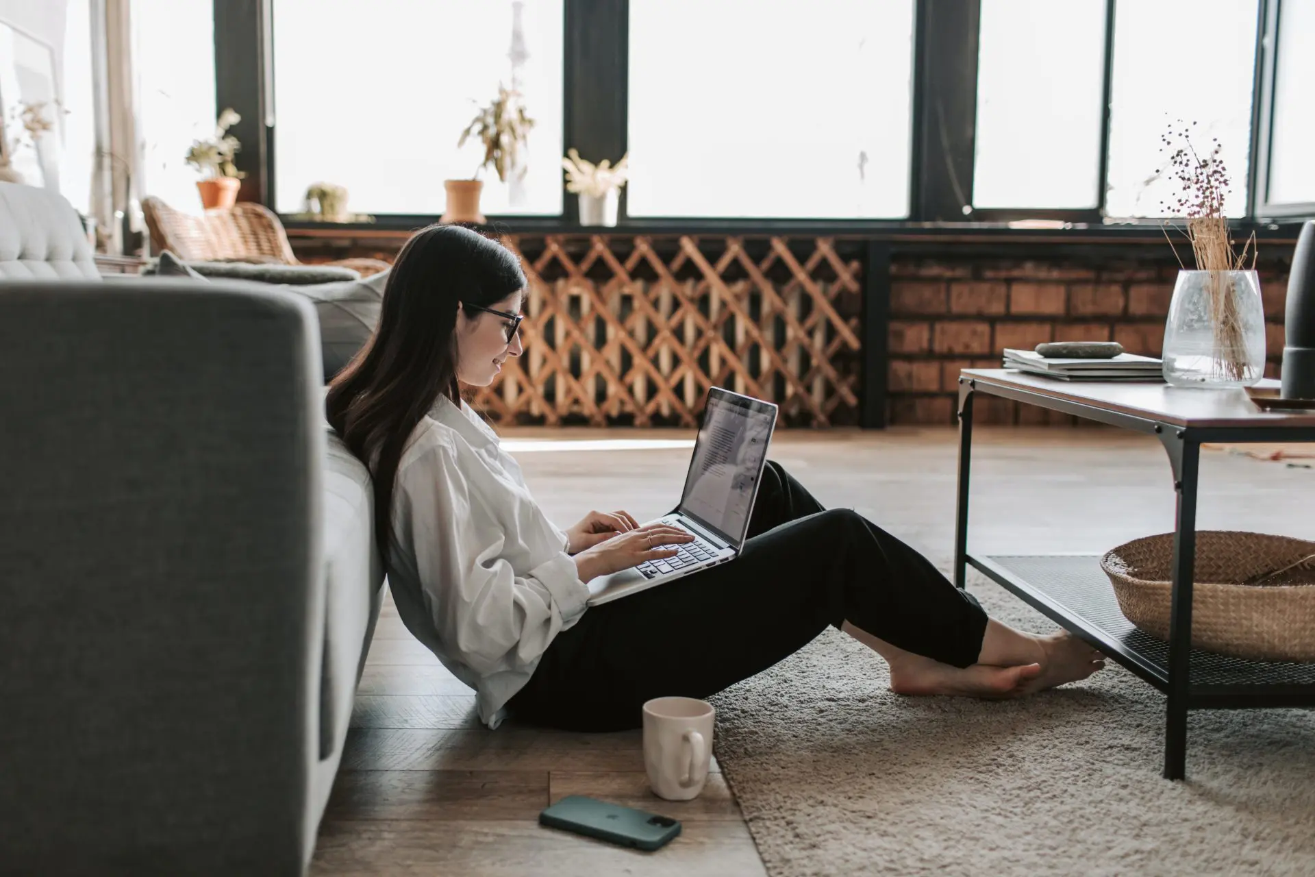 business woman sitting on the floor of office on computer