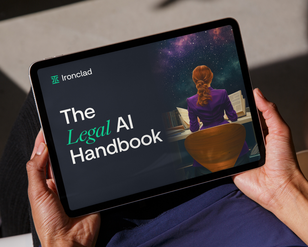 A person holds a tablet displaying an e-book titled The Legal AI Handbook by Ironclad, featuring an illustration of a woman sitting at a desk with an open book and a starry background.