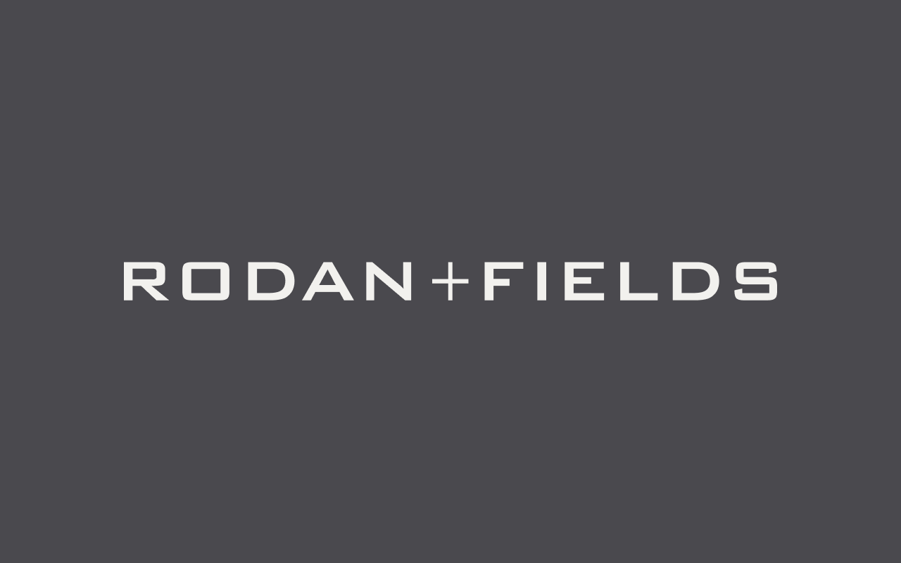 White text on a dark gray background reads “RODAN + FIELDS” in all capital letters, showcasing the signature rodan and fields branding with a plus sign between the two words.